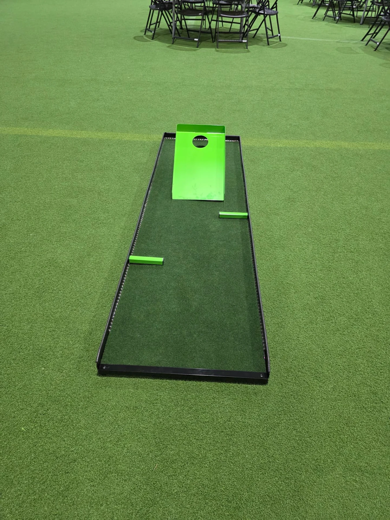 Full Putt Zone Texas mini-golf lane with green bumpers and a green ramp with a circular opening