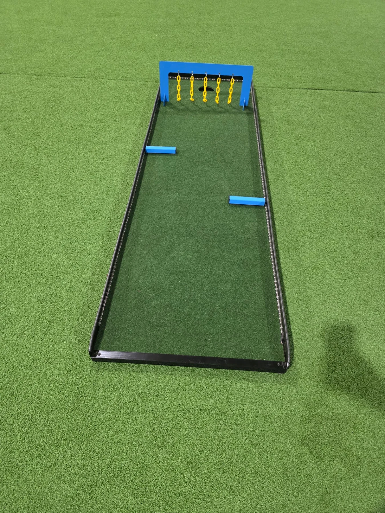 Putt Zone Texas mini-golf lane with blue bumpers and yellow hanging chains
