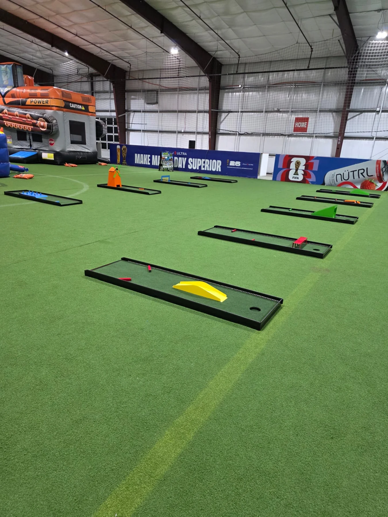 Putt Zone Texas portable mini-golf lanes arranged across an indoor turf venue
